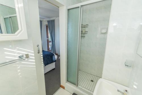 baño con ducha y puerta de cristal en The Heads Luxury 3 Bedroom en South End