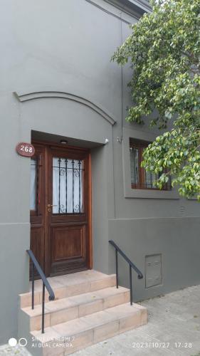a set of stairs leading to a wooden door at Espectacular casa centro laguna para parejas in Chascomús