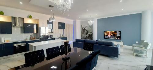 uma sala de estar com um sofá, uma mesa e uma televisão em 4 on Pritchard Luxury Suites em Joanesburgo