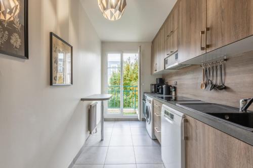 une cuisine avec un évier et un lave-vaisselle dans l'établissement Family Apartment DisneyLand 90m2 - 150m RER A Val d Europe, à Chessy