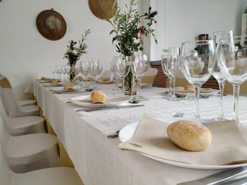 una mesa larga con copas de vino y pan. en Ca Les Senyoretes en Otos