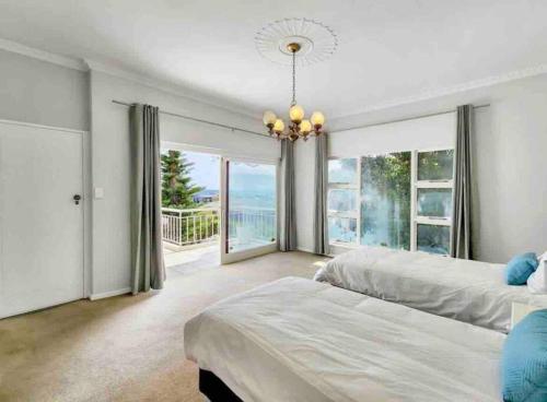 a bedroom with two beds and a large window at Fresnaye Family Home with Ocean Views in Cape Town