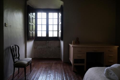 a bedroom with a desk and a chair and a window at CASA RURAL PALACIO CONDE DE ALDANA con piscina entre encinares y dehesas in Terradillos