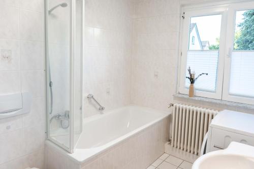 uma casa de banho branca com uma banheira e um chuveiro em Ferienwohnung in bester Lage 2 em Rust