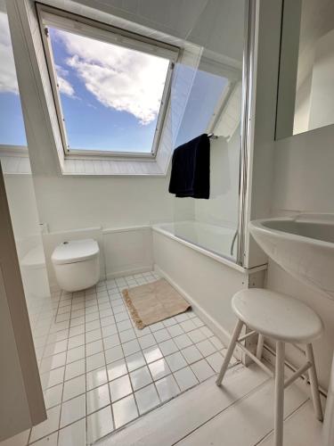 a bathroom with a window and a toilet and a sink at Le Crotoy - Entre ciel et mer in Le Crotoy