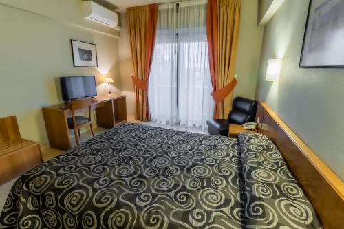 a hotel room with a bed and a window at Hotel Alhama in Cintruénigo