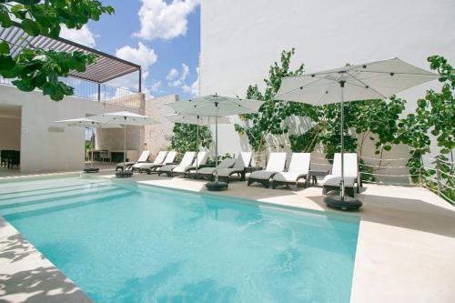 a swimming pool with chairs and umbrellas at Nido De Tortuga Akumal With Beach Access And Private Jacuzzi in Akumal