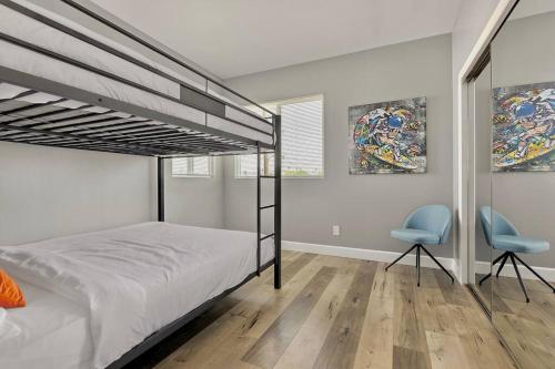 a bedroom with a bunk bed and two chairs at Fun Mid-City New Home Sleeps 10 Near USC/DTLA/Expo in Los Angeles