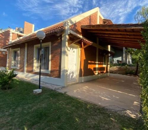 een huis met een veranda en een garage bij Cabañas Rincón Potrero in Potrero de los Funes