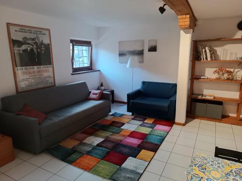 ein Wohnzimmer mit einem Sofa und einem bunten Teppich in der Unterkunft Amnis in Aquiléia