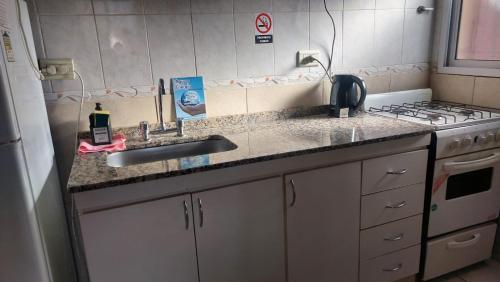 a kitchen counter with a sink and a stove at Cabañas Rincón Potrero in Potrero de los Funes
