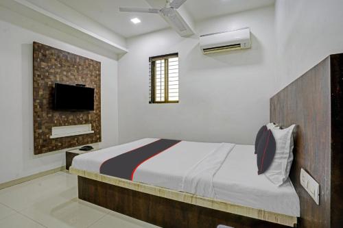 um quarto com uma cama e uma televisão na parede em Hotel Krishna Inn em Mumbai