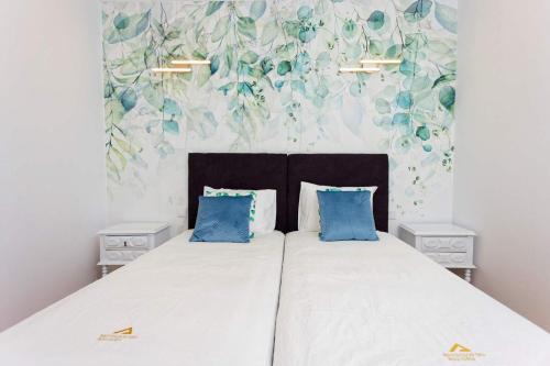 - une chambre avec un grand lit et des oreillers bleus dans l'établissement Quinta Refúgios do Rio Dão, à Mangualde