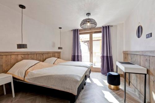 une chambre avec deux lits et une fenêtre dans l'établissement Lodge 10 personnes proche pistes et commerces belle vue, à Champagny-en-Vanoise
