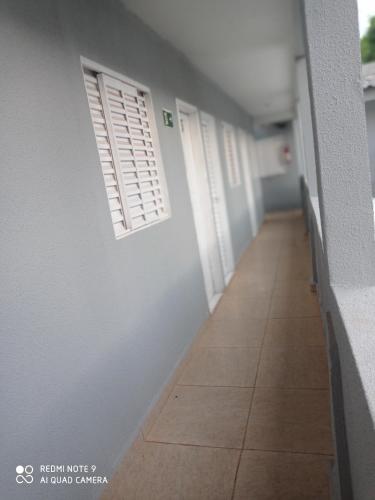pasillo con puertas blancas y suelo de baldosa en Hotel Veneza, en Ribas do Rio Pardo
