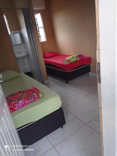 Habitación pequeña con 2 camas y baño. en Hotel Veneza, en Ribas do Rio Pardo