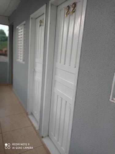 un par de puertas blancas en un pasillo en Hotel Veneza, en Ribas do Rio Pardo
