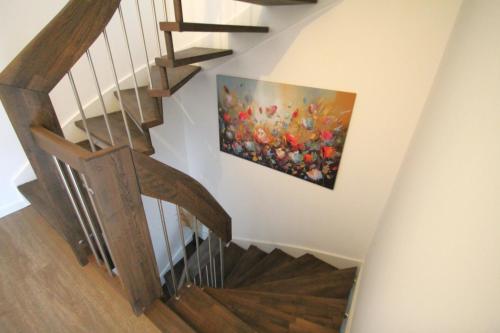 a staircase with a painting of flowers on the wall at Sunseeker House 2 in Bad Schwartau