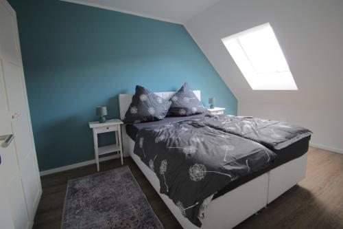 een slaapkamer met een bed met een blauwe muur bij Sunseeker House 2 in Bad Schwartau