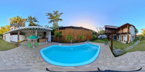 a large pool in a yard next to a house at Flats Maraú - Taipu de Fora Bahia in Marau
