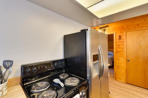 a kitchen with a stove and a refrigerator at Decks and Fire Pit Rustic-Modern Overgaard Cabin! in Overgaard