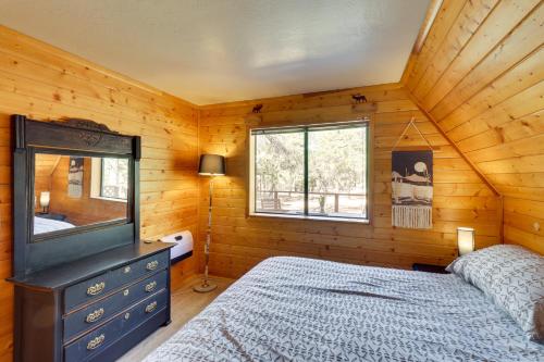 a bedroom with a bed and a dresser and a window at Decks and Fire Pit Rustic-Modern Overgaard Cabin! in Overgaard