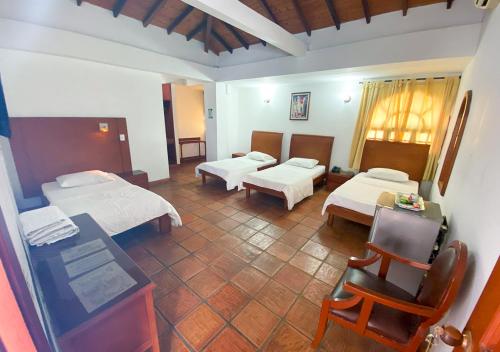 a hotel room with two beds and a table and chairs at Hotel Zaraya in Cúcuta