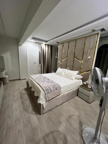 a bedroom with a large bed and a fan at Comfort and Quit Apartment جاردينيا سيتي in Cairo