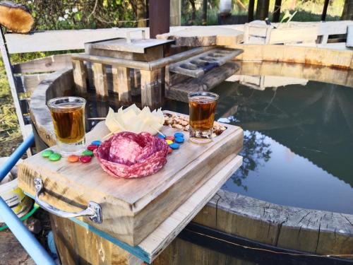 una mesa con dos vasos de cerveza y un tazón de comida en Cabaña AlaSa en Los Ángeles