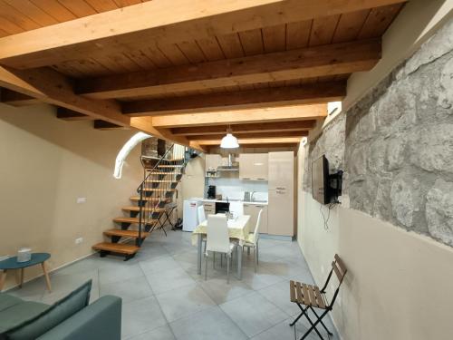 a dining room and kitchen with a stone wall and wooden ceilings at Il Paradosso Suite in Viterbo