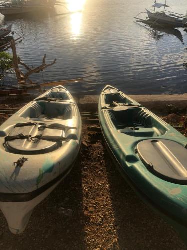 two canoes sitting on the shore of a body of water at Sanctuaria Treehouses Busuanga in Busuanga