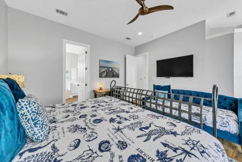 een slaapkamer met een blauw bed en een televisie bij Our Destiny in Dunes of Destin - Is a 4BR with Private Pool and close Beach Access in Destin