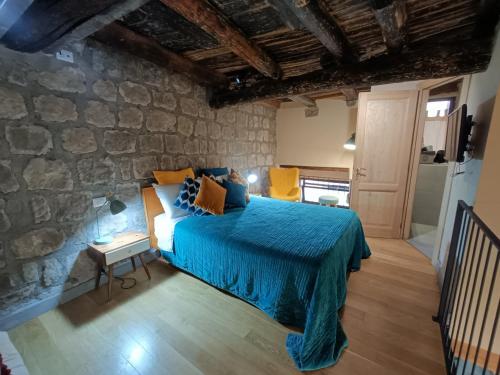 una camera con letto e parete in pietra di Il Paradosso Suite a Viterbo