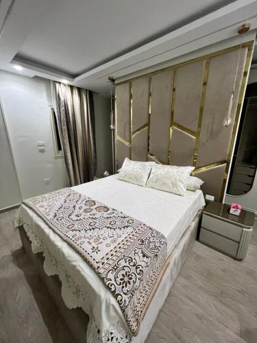 a bedroom with a large bed with a white blanket at Comfort and Quit Apartment جاردينيا سيتي in Cairo