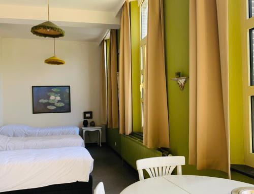 two beds in a room with green and yellow walls at De Lotuspoort met Mihr's B&B in de Abdij van Bornem in Bornem