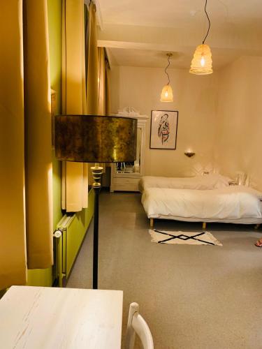 a bedroom with a bed and a table in it at De Lotuspoort met Mihr's B&B in de Abdij van Bornem in Bornem