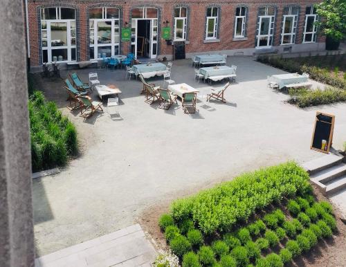 an overhead view of a courtyard with tables and chairs at De Lotuspoort met Mihr's B&B in de Abdij van Bornem in Bornem