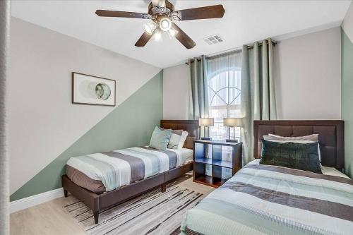 a bedroom with two beds and a ceiling fan at Gorgeous and Spacious home! in Las Vegas