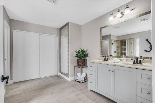 a white bathroom with two sinks and a mirror at Gorgeous and Spacious home! in Las Vegas