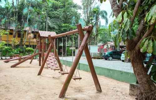 a playground in a park with a tree at Hotel Saveiros in Ubatuba