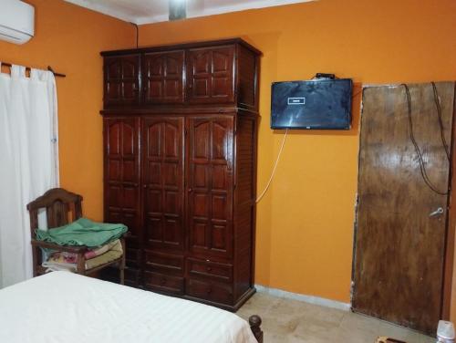 1 dormitorio con un gran armario de madera junto a una cama en La Bea en Recreo