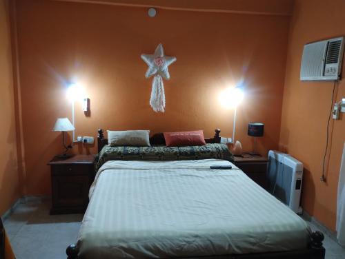 1 dormitorio con 1 cama y una estrella en la pared en La Bea en Recreo