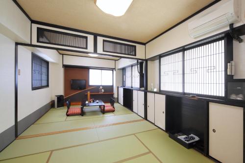 a large room with a table and some windows at Hotel Chatelet Inn Kyoto in Kyoto