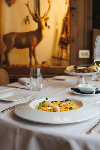 a table with a plate of food and a deer on it at Camana Veglia in Livigno
