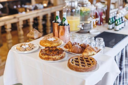 a table topped with different types of pastries on plates at Camana Veglia in Livigno