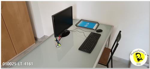 uma secretária com um monitor de computador e um computador portátil em Pulcino Furioso Magenta em Gênova
