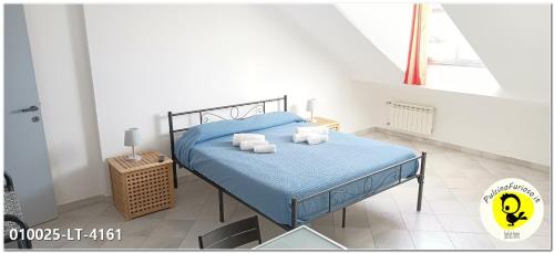 um quarto com uma cama com lençóis azuis e toalhas em Pulcino Furioso Magenta em Gênova