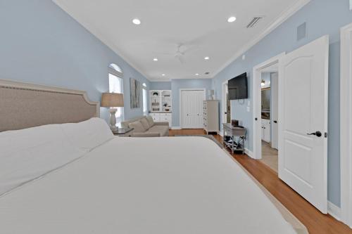 een slaapkamer met een groot wit bed en een woonkamer bij Palmetto Palms - 4BR in Emerald Shores in Destin