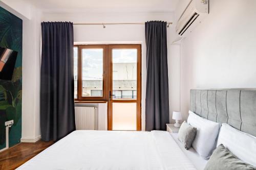 a bedroom with a large bed and a window at Downtown Victoria Apartments By CityBookings in Bucharest