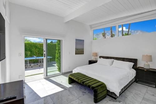 a bedroom with a bed and a large window at Palm Springs Luxury Home With Pool and Next to Downtown & Airport in Palm Springs